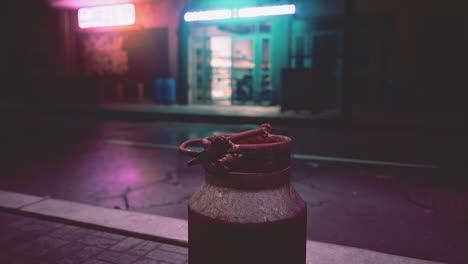 a rusty metal can sits on a deserted street at night