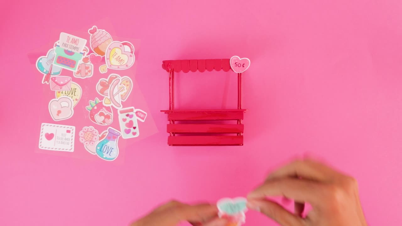 Decorating miniature kissing booth for Valentine's day with stickers