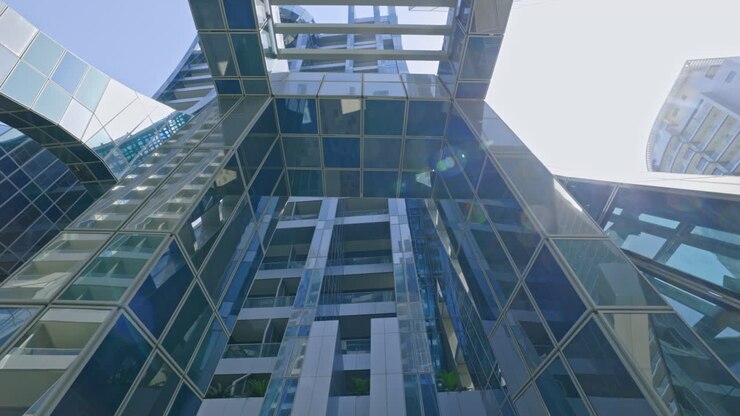 Imponenti grattacieli moderni in vetro e riflessi architettonici visti dal basso