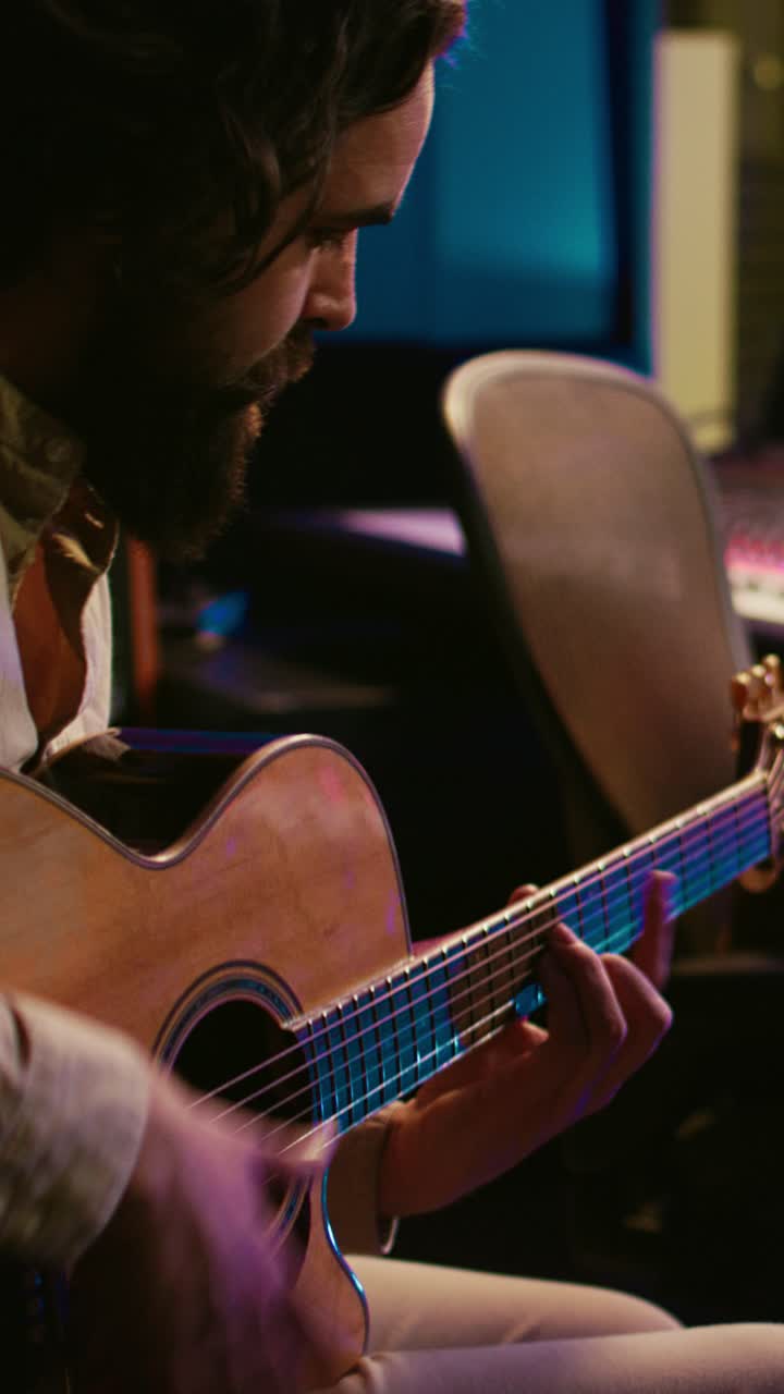 Hombre con barba tocando la guitarra acústica en un estudio de música