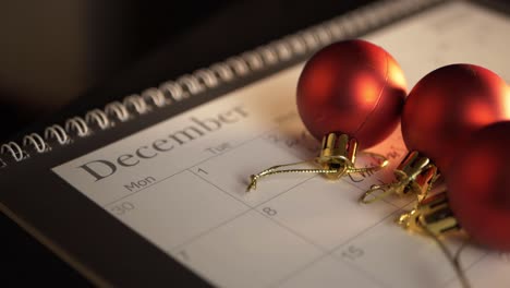 red baubles on calendar at christmas close up panning shot