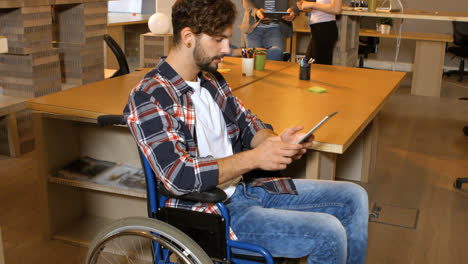 ejecutivo de negocios masculino sentado en silla de ruedas y usando una tableta digital