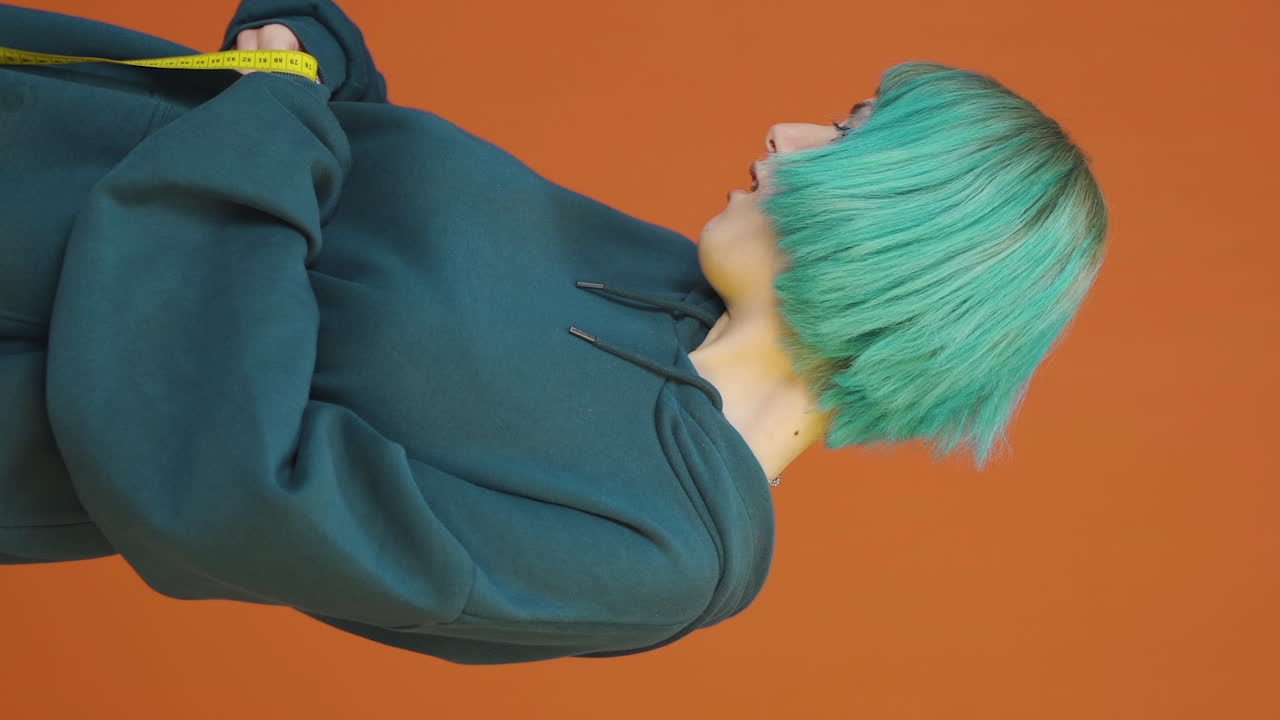 자신의 몸무게에 만족하는 젊은 여성의 수직 비디오.