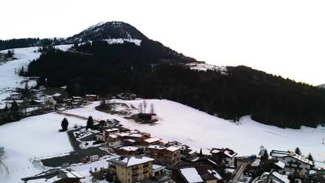 alpes nevados y el municipio de kirchberg en austria, vista aérea de un dron