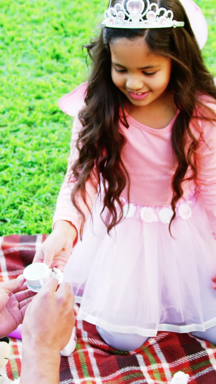 padre e hija teniendo una fiesta de té de juguete