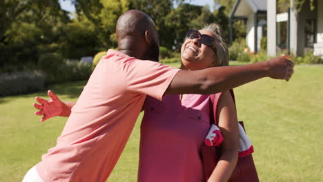 hugging outdoors, senior friends smiling and enjoying sunny day in park