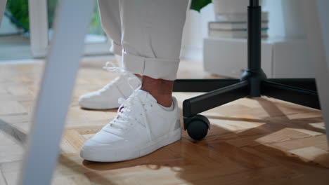 white man shoes sitting chair home closeup. contemporary freelancer legs moving