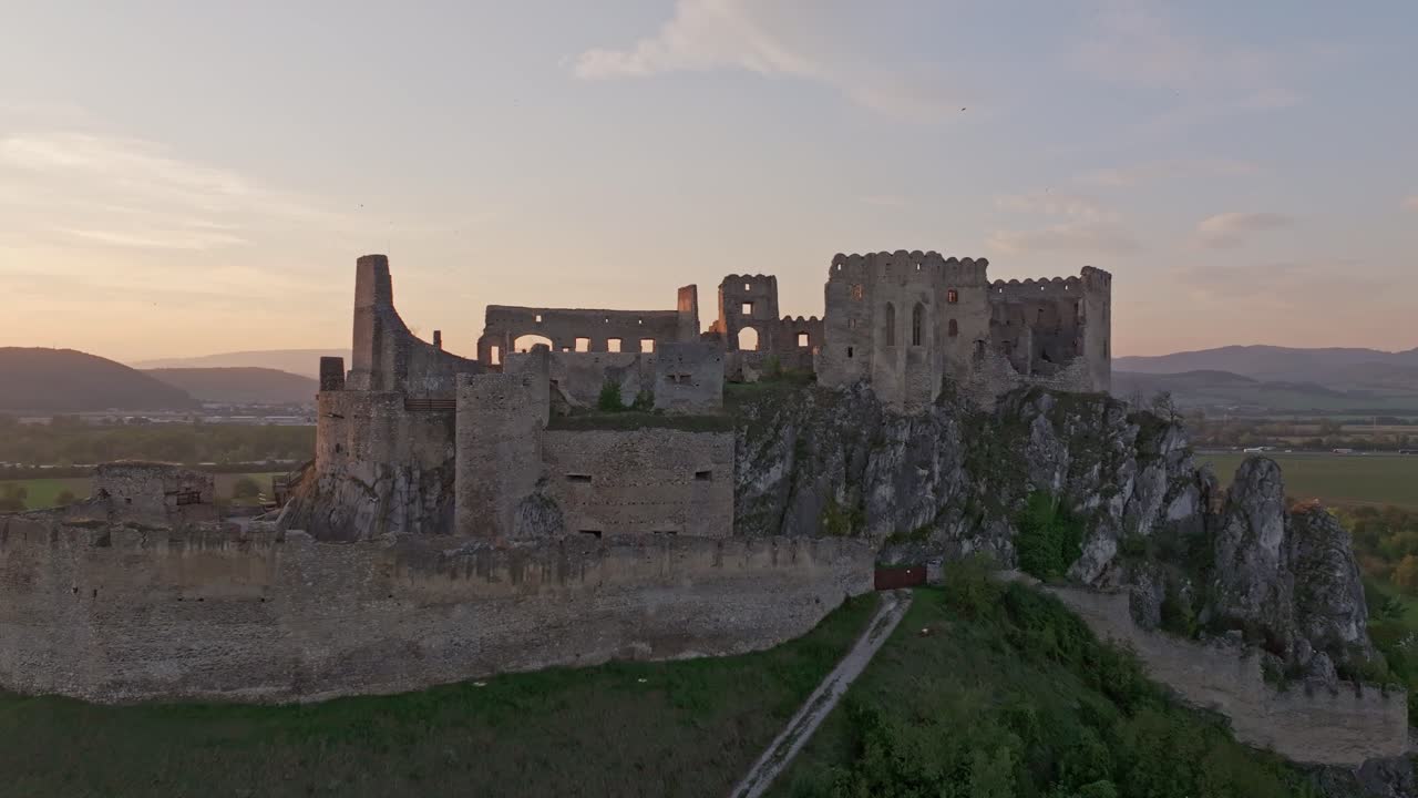 Ripresa con drone del Castello di Beckov che risplende alla luce del tramonto, Slovacchia