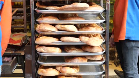 stacked bread on metal trays in a bakery