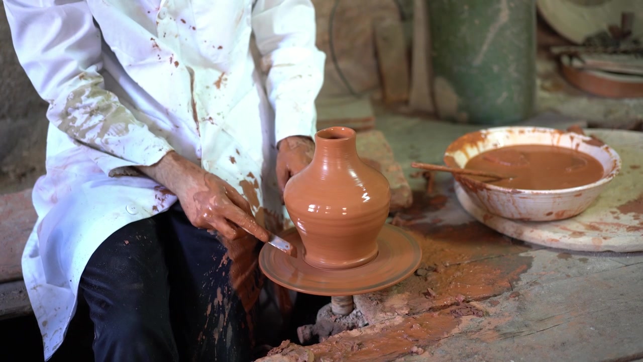 Artigiano che modella un pezzo di ceramica su un tornio da vasaio arabo.
