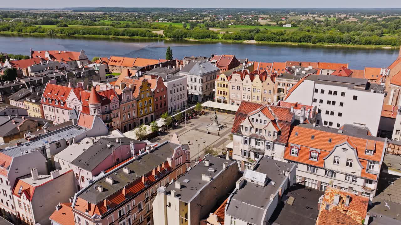 Establishing aerial shot of Grudziądz rooftops as birds glide over Vistula River
