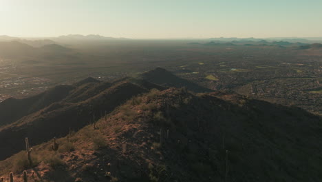 Slow-aerial-push-in-over-mountain-towards-Anthem,-Arizona-in-valley