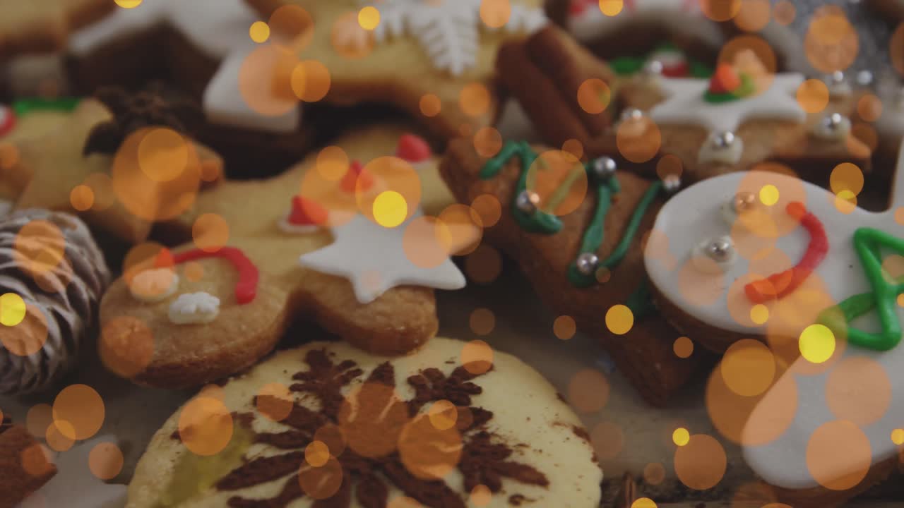 animación de puntos de luz amarillos y naranjas sobre hombres de pan de jengibre de navidad y galletas decoradas