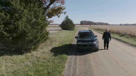 suv on a country road having car trouble opening hood