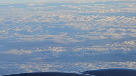 aerial view through airliner or plane window on cloudy sky along with the engine turbine