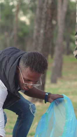 volunteers engaging in an environmental cleanup, collecting litter in a blue bag