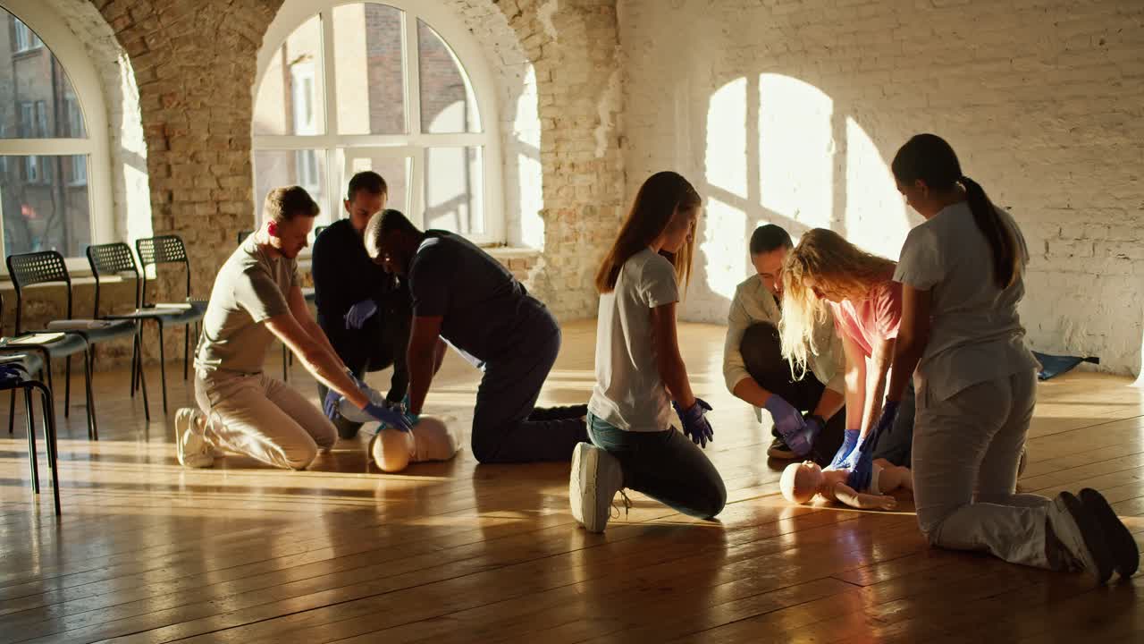 블루 유니폼을 입은 흑인 의사와 색 유니폼를 입은 간호사 소녀가 다양한 마네킨을 사용하여 응급 치료 훈련을 수행합니다.