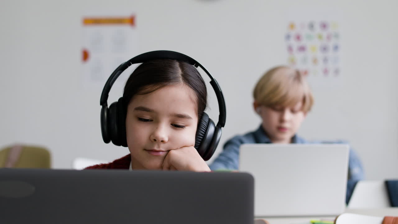 estudiantes trabajando en computadoras portátiles en un aula