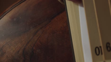 una mano saca un formulario del libro de archivo retro