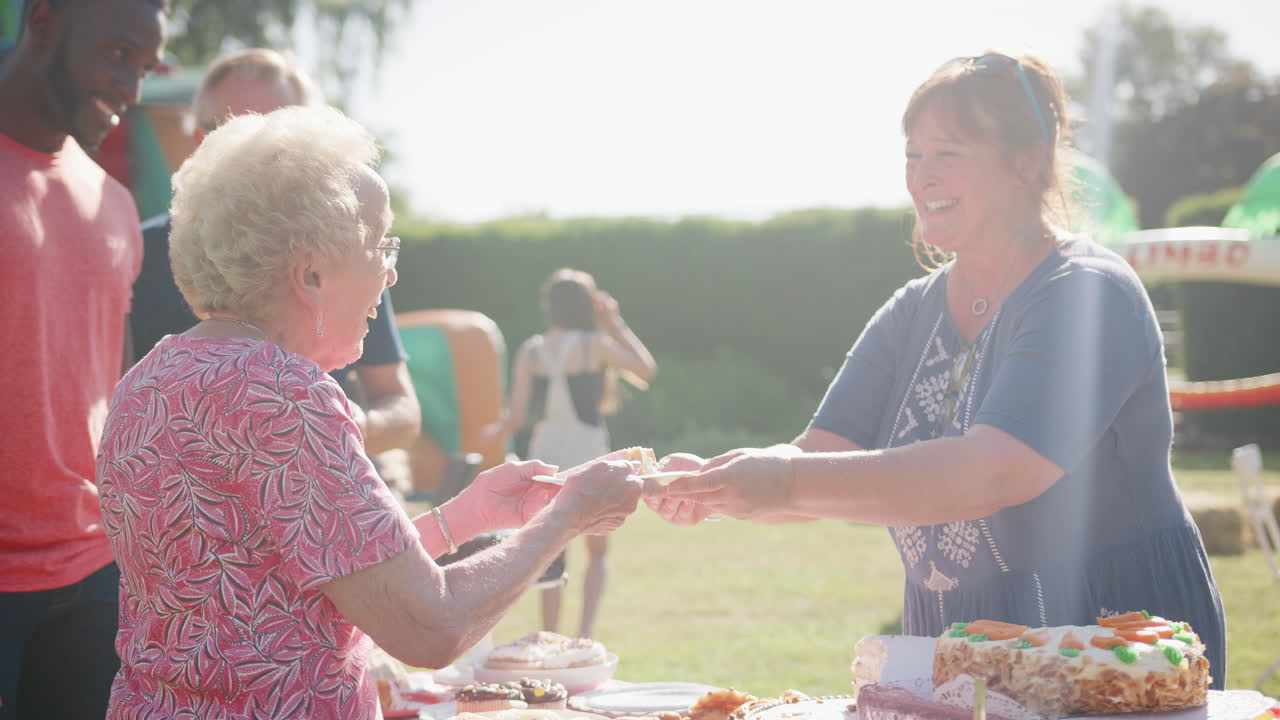 여름 정원 축제 에서 케이크 가게 에서 제공 되고 있는 고령 여성 의 느린 동작  ⁇