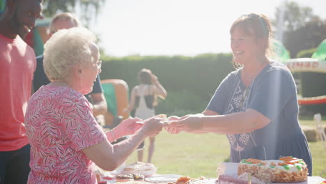 Toma-En-Cámara-Lenta-De-Una-Anciana-Servida-En-Un-Puesto-De-Pasteles-En-La-Fiesta-Del-Jardín-De-Verano