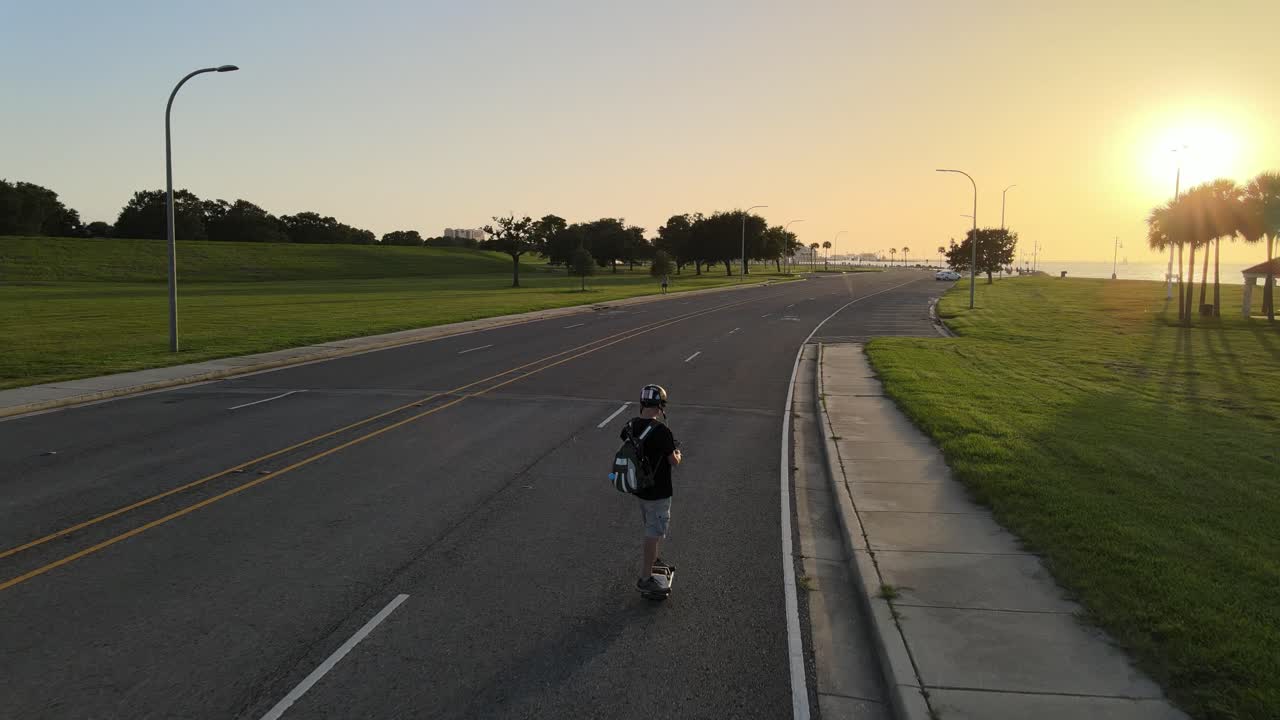 Uomo pattina su un'autostrada deserta al tramonto a Lakeshore Drive, New Orleans, USA. Carrellata.