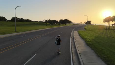 man skates at the vacant highway during sunset in lakeshore drive, new orleans, usa. tracking shot