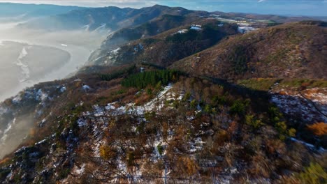 tiro de adelantamiento fpv de bosques de wachau ligeramente nevados seguido de un tiro descendente aventurero en bocanadas de niebla