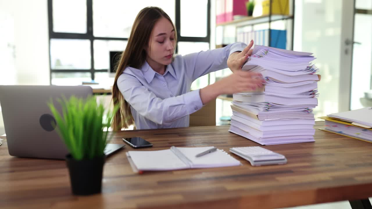 Woman Overwhelmed by Paperwork in Office