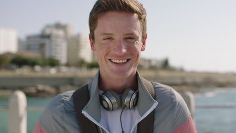 retrato de cerca de un joven alegre sonriendo feliz en una playa soleada