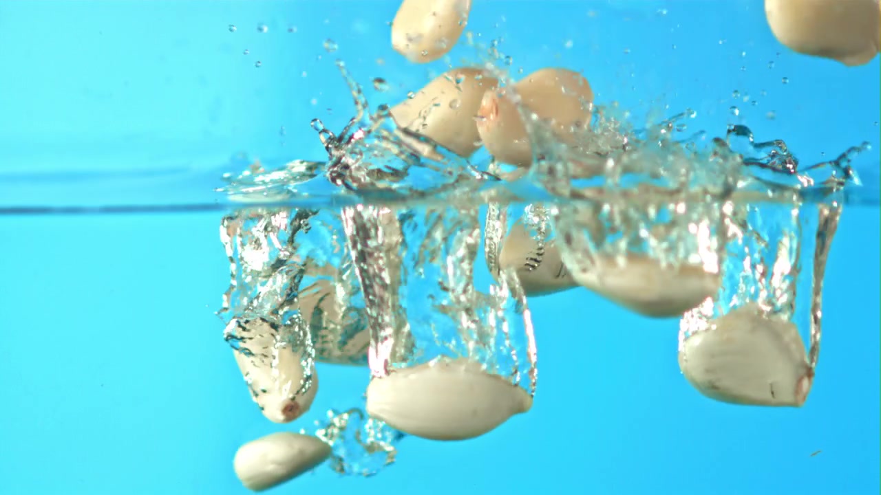 Garlic Cloves Falling into Water in Slow Motion
