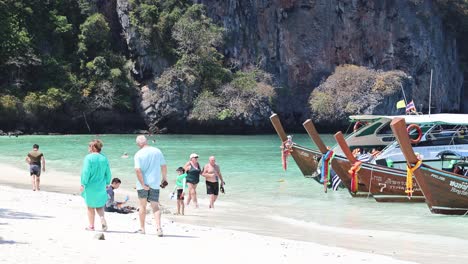 people disembarking and walking on a tropical beach