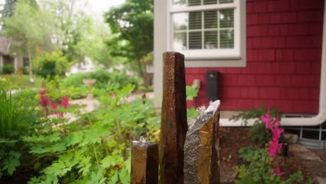 orbiting shot of a unique and modern water fountain outside of a home