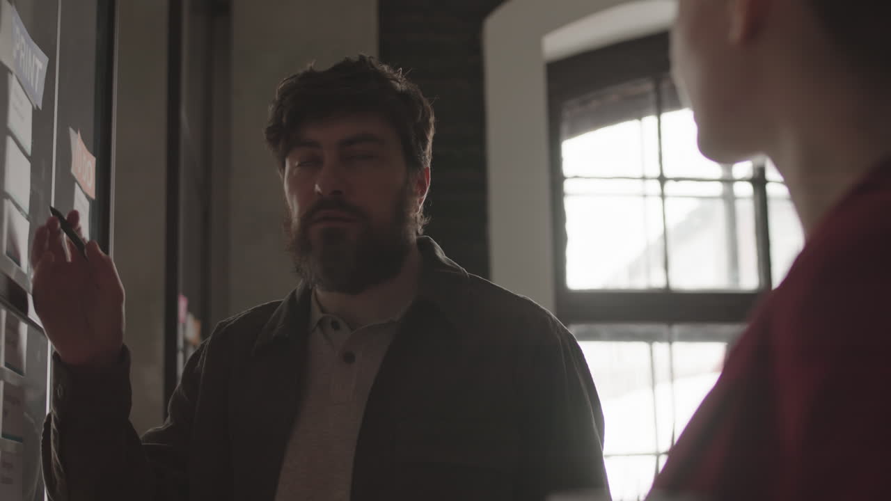 Employee Doing Notes on Glass Board