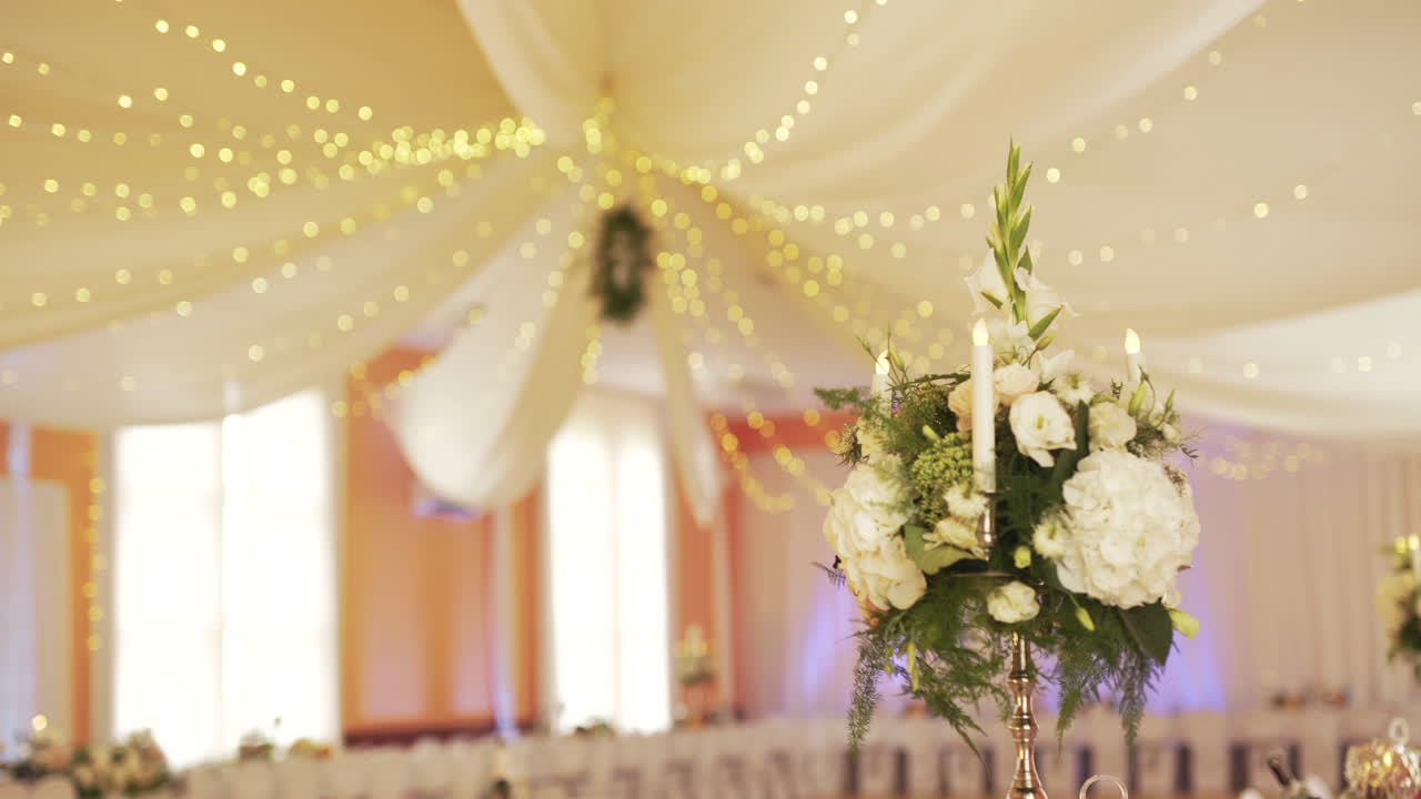 Elegante Decorazione per Ricevimento di Matrimonio con Centrotavola Floreale e Luminarie