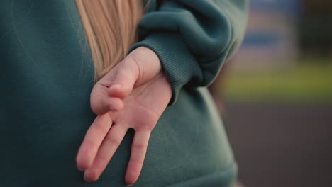 close up back view of lady slightly bent making hand gestures, two other ladies in background also slightly bent in blurred view, participating in group physical activity outdoors