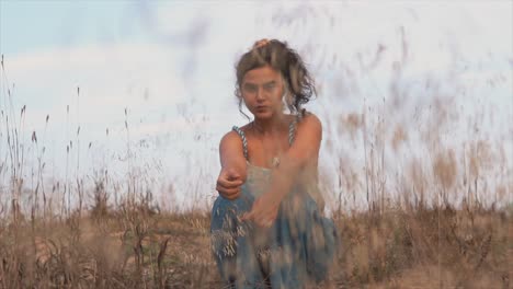 a portrait of a woman sitting in tall grass and enjoying sunset