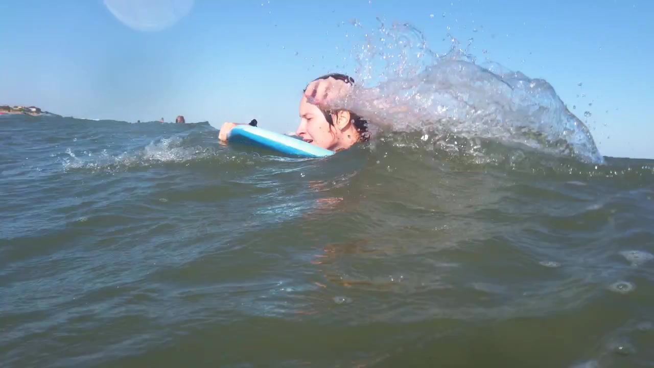 La surfista sulla tavola da surf sulle onde
