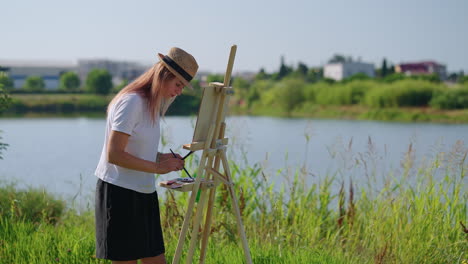 woman painting outdoors by a lake