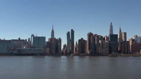 an aerial view over a calm east river on a sunny day with blue skies