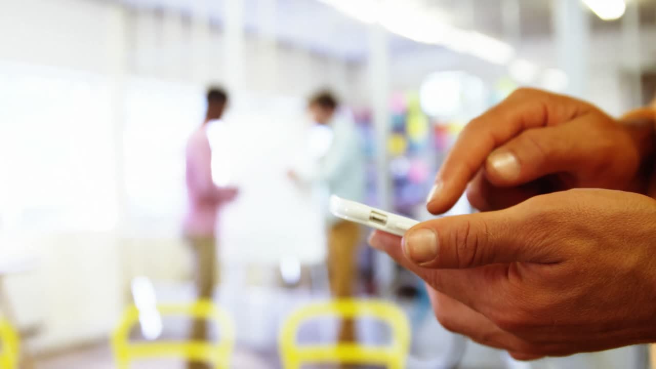 sección media de ejecutivo de negocios masculino mensajes de texto en el teléfono móvil