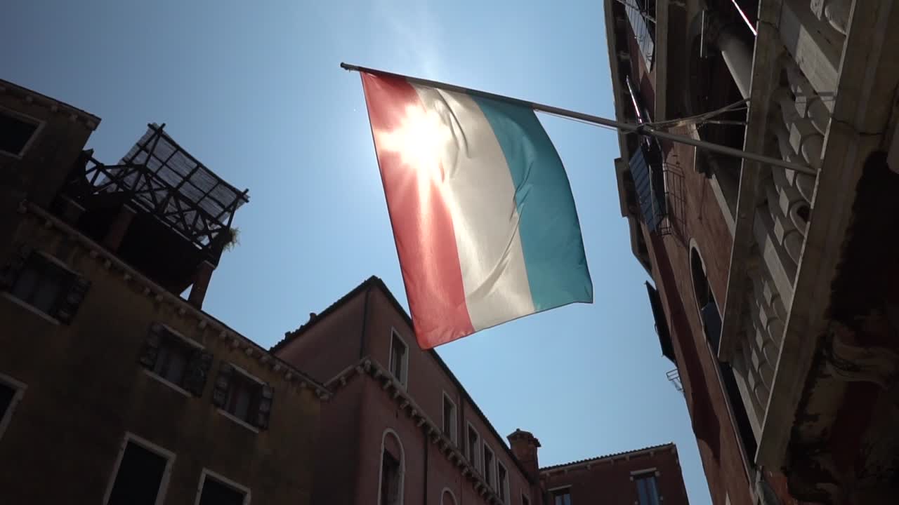 Bandiera olandese su un balcone, con il sole radioso che splende da dietro