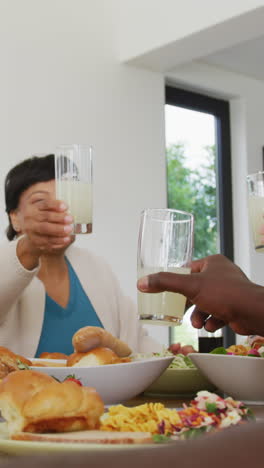 happy senior diverse people having dinner at retirement home