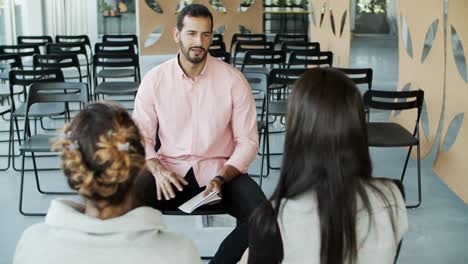 Handsome-young-worker-speaking-to-colleagues