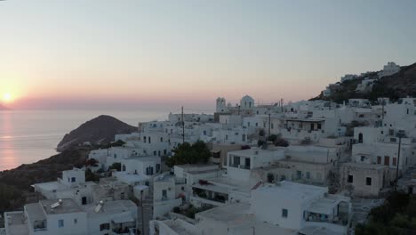 beautiful aerial view over generic greek village small town with ocean view, sunset