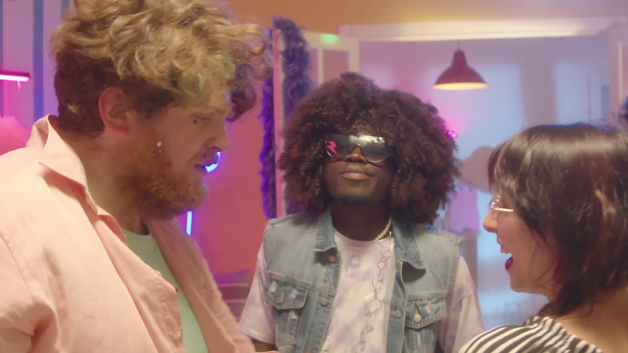 Friends Dancing and Celebrating in a Neon-Lit Room