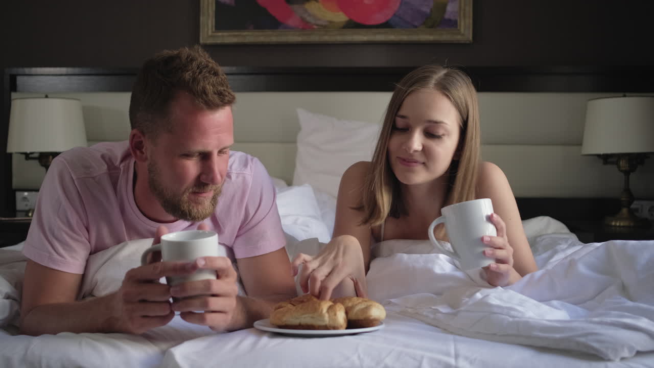 Coppia godendo la colazione a letto