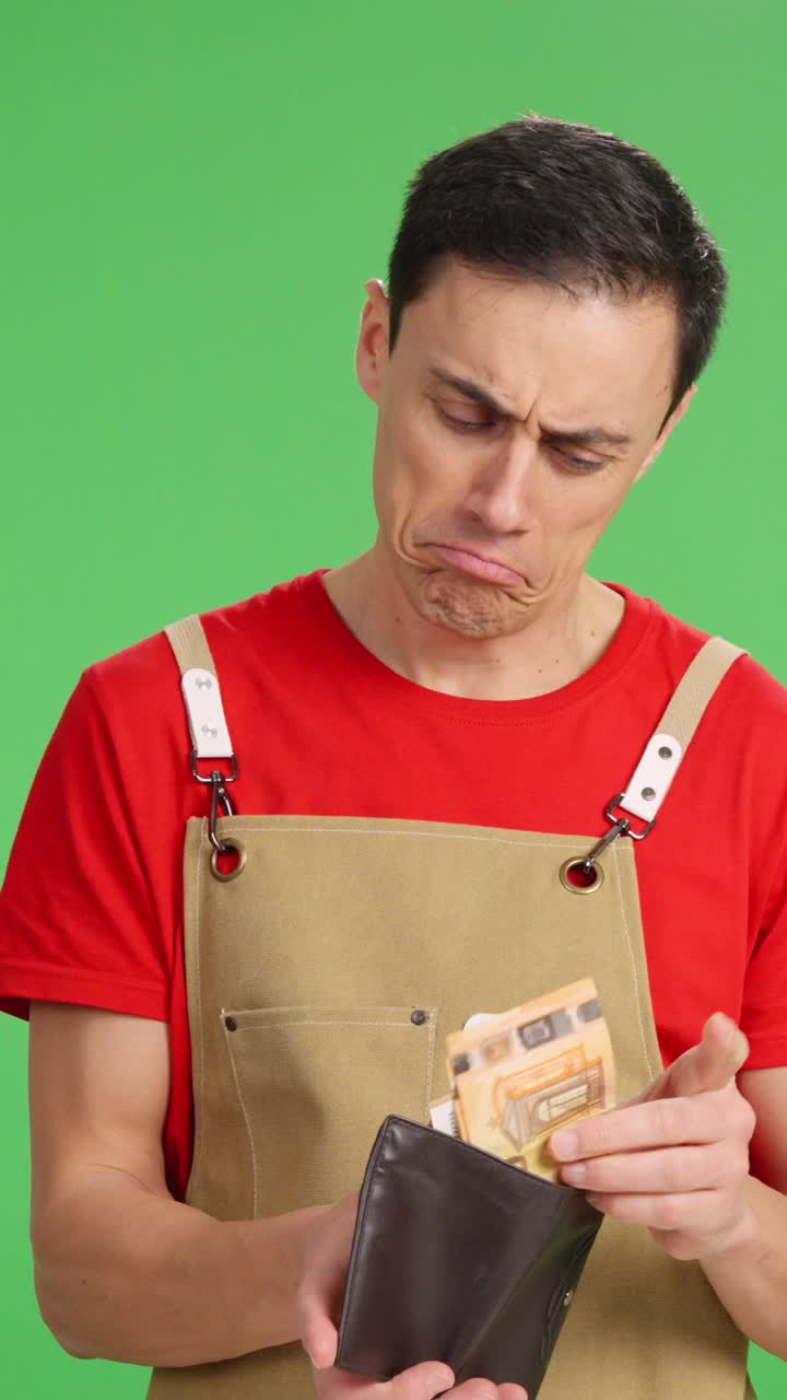 Happy entrepreneur checking money in wallet on green screen