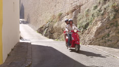 una pareja joven montada en un scooter, ibiza, españa, filmado en r3d