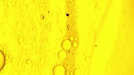 gel aceitoso amarillo que fluye sobre una superficie similar a una mancha con burbujas de aceite